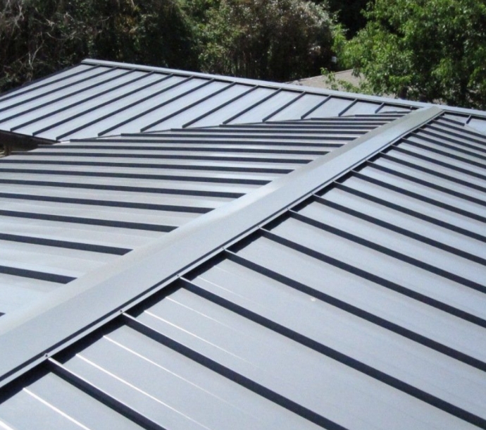 Close-up of a modern home's metal roof with standing seam panels and clean lines, highlighting the durability and sleek design of contemporary roofing materials.