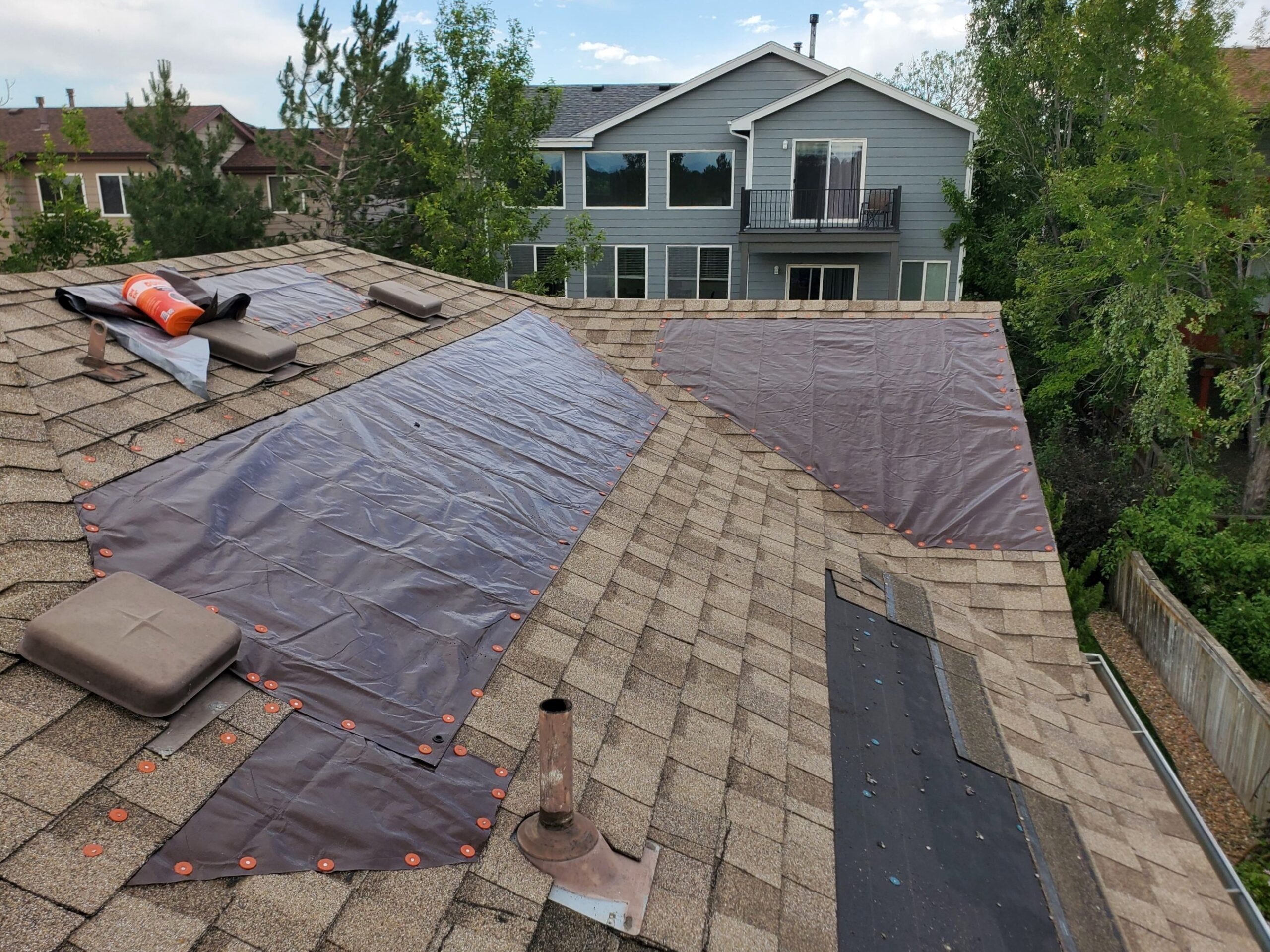Tarp-covered section of a residential roof indicating repair work in progress.