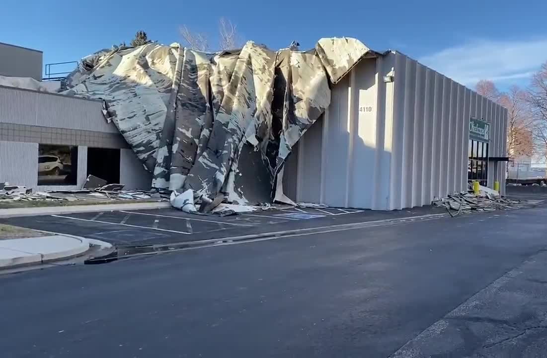 Collapsed roof on a commercial building with debris scattered around.