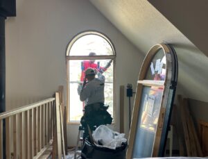 two contractors taking out an old window in a residential home to replace it with the best replacement window