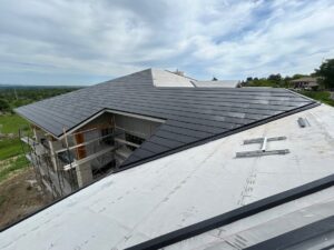 overhead image of a roof where contractors are installing solar tiles for roof replacement project