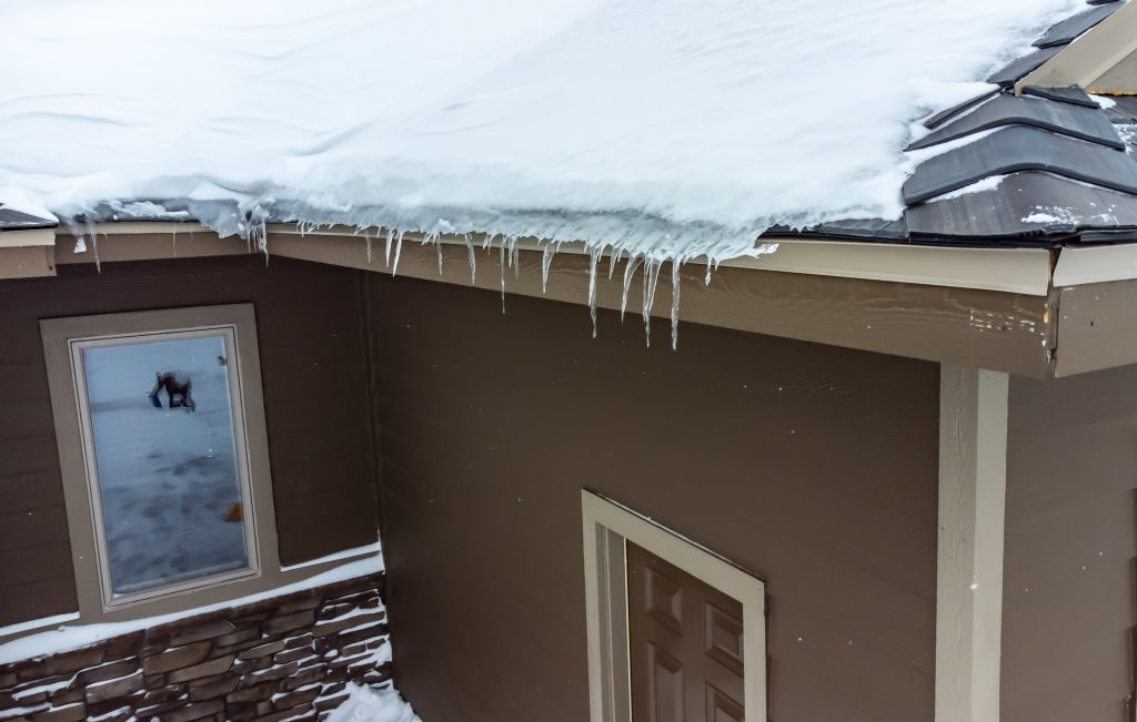 Elevated view of snow and icecicles on roof and need for getting rid of ice dams on roof