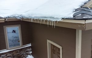Elevated view of snow and icecicles on roof and need for getting rid of ice dams on roof