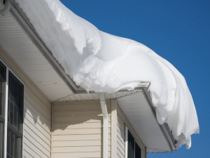 hail damaged roof of a residential home in colorado covered in snow