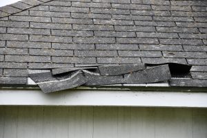 damaged asphalt shingle roof in need of roofing insurance claims