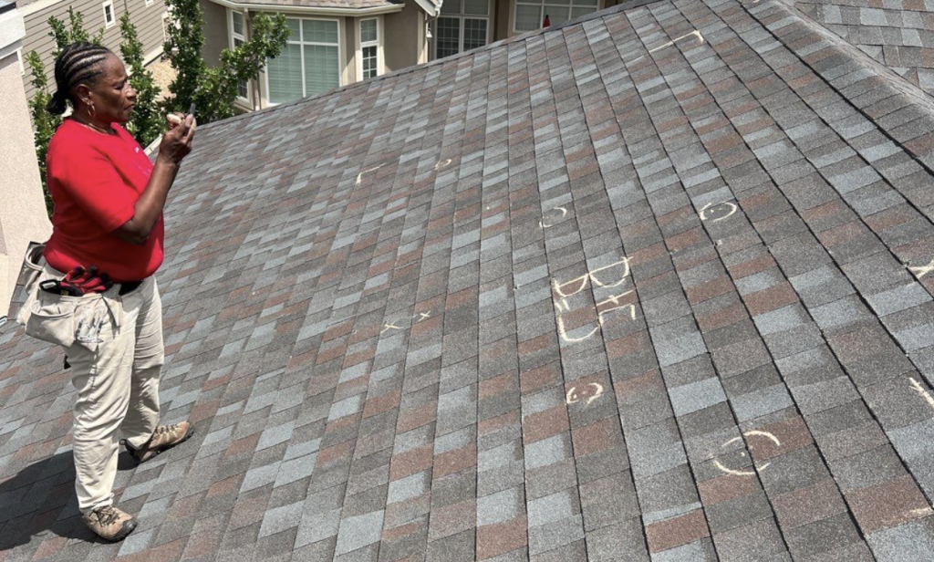 insurance adjuster on a damaged roof making chalk marks for roofing insurance claims