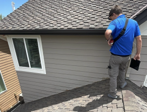 roof insurance adjuster standing on a residential roof assessing damage after a storm